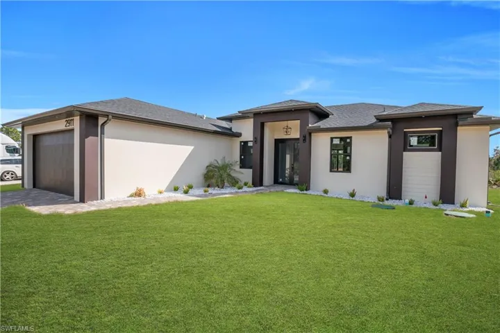 Prairie-style home with stucco siding, a front yard, and an attached garage