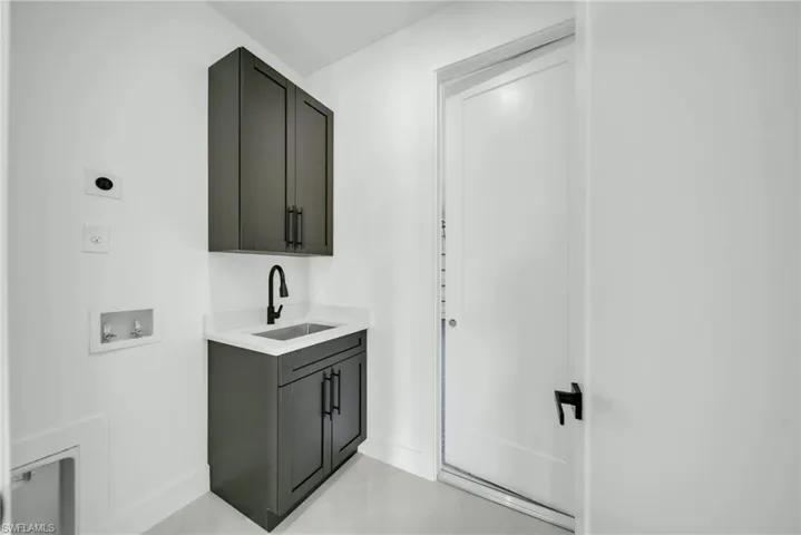 Bar area featuring light stone counters and gray cabinets