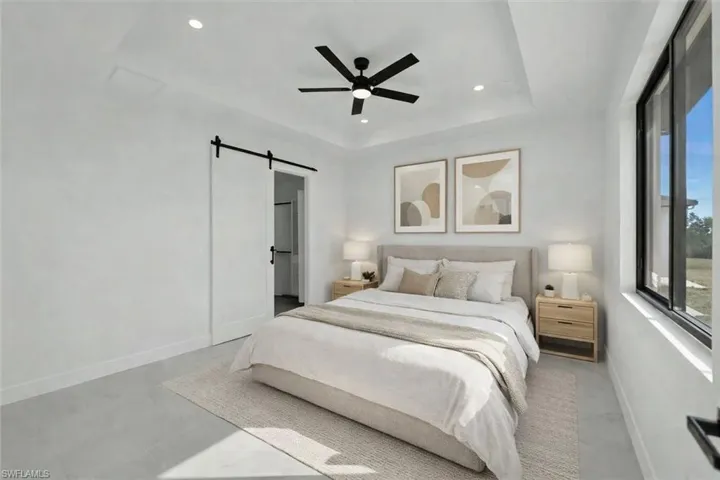 Bedroom featuring a barn door, a ceiling fan, recessed lighting, and concrete floors