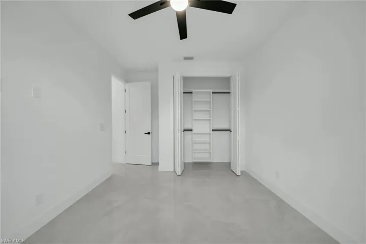 Unfurnished bedroom featuring a closet, ceiling fan, and concrete floors