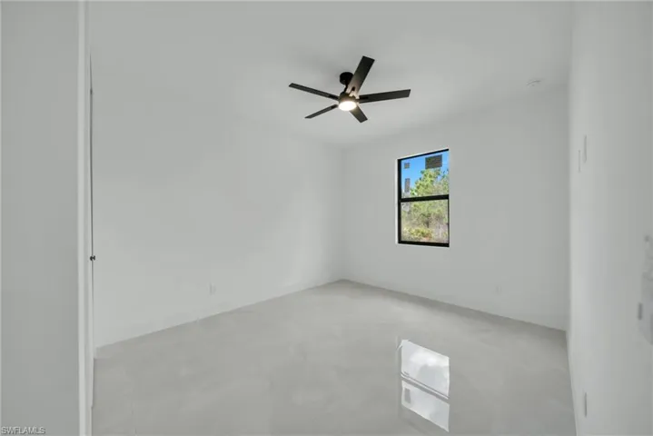 Unfurnished room featuring concrete flooring and ceiling fan