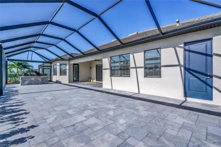 Rear view of property with a patio, a lanai, a ceiling fan, and stucco siding