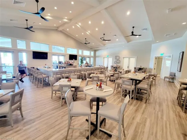 Dining room featuring ceiling fan, high vaulted ceiling, light wood-style floors, beam ceiling, and recessed lighting