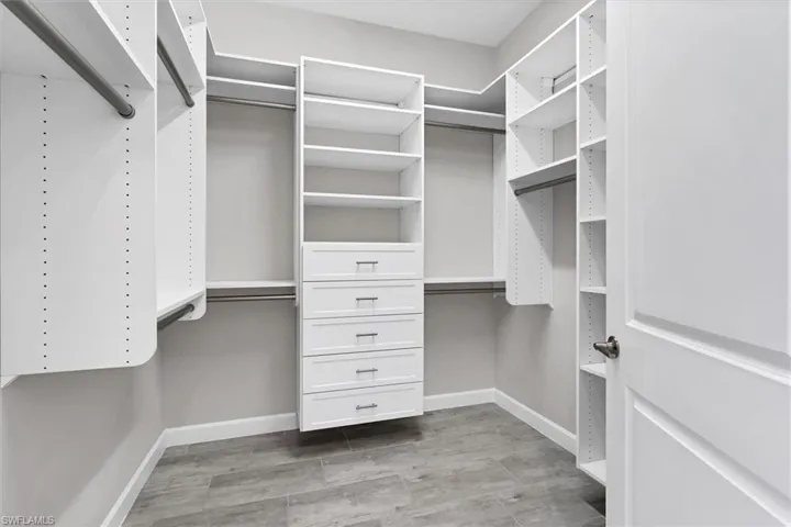 Walk in closet with wood finished floors