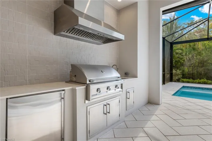 Beautiful outdoor kitchen with refrigerator, natural gas grill and sink with touchless faucet