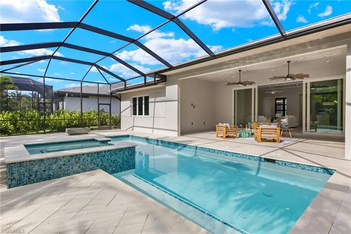 View of pool with an in ground hot tub, a patio, and a lanai