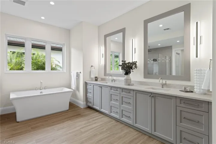 Bathroom with double sink, plus walk in shower, and large vanity