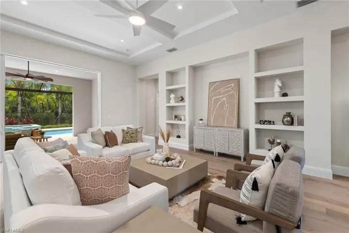 Living room featuring ceiling fan, light hardwood / wood-style floors, and built in shelves