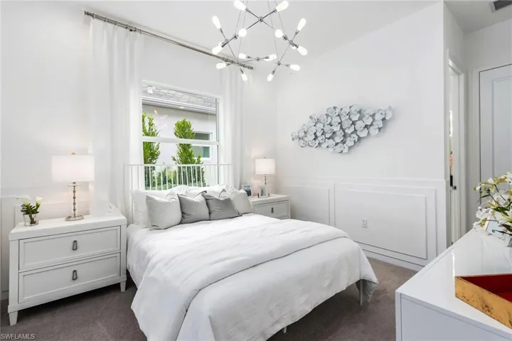Bedroom with dark colored carpet and a chandelier