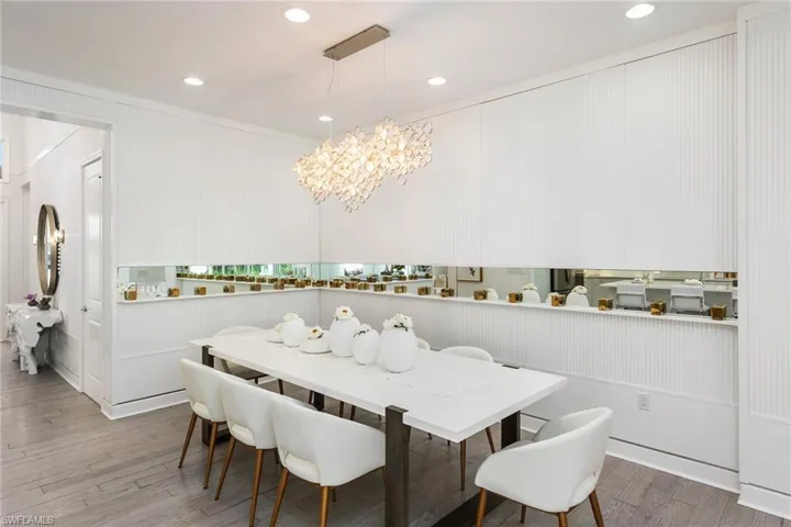 Dining area with an inviting chandelier, ornamental molding, and light hardwood / wood-style flooring