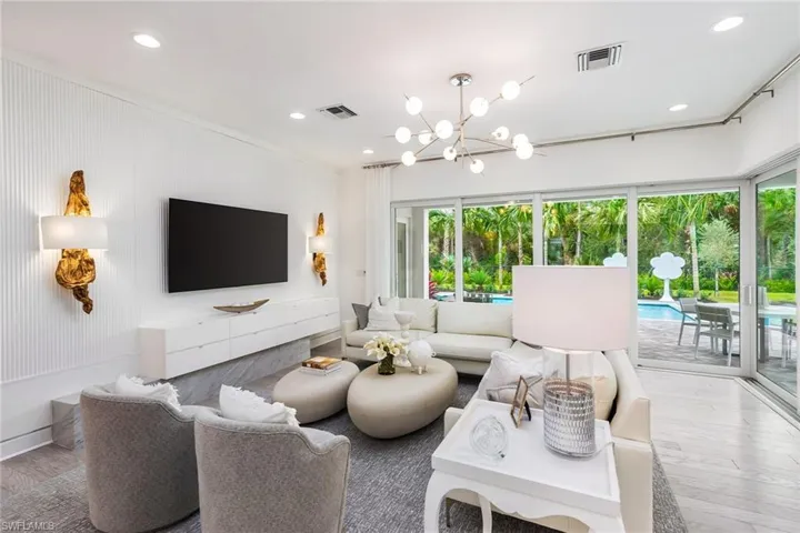 Living room featuring ornamental molding, a notable chandelier, and hardwood / wood-style flooring