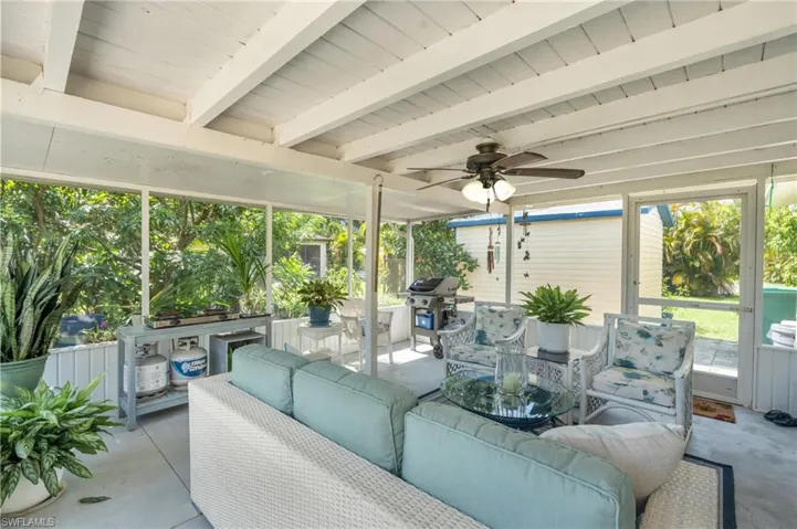 Sunroom / solarium featuring beam ceiling and ceiling fan