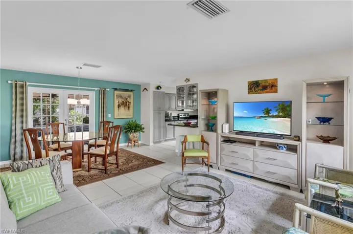Living room with light tile patterned floors and a chandelier