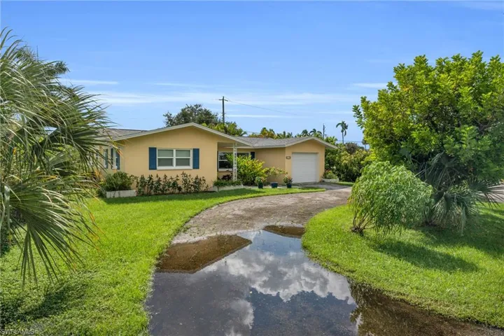 Single story home with a front yard and a garage