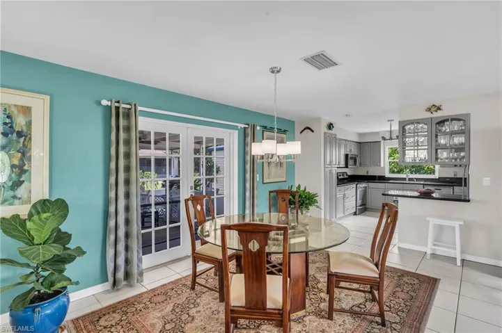 Tiled dining area featuring an inviting chandelier and sink