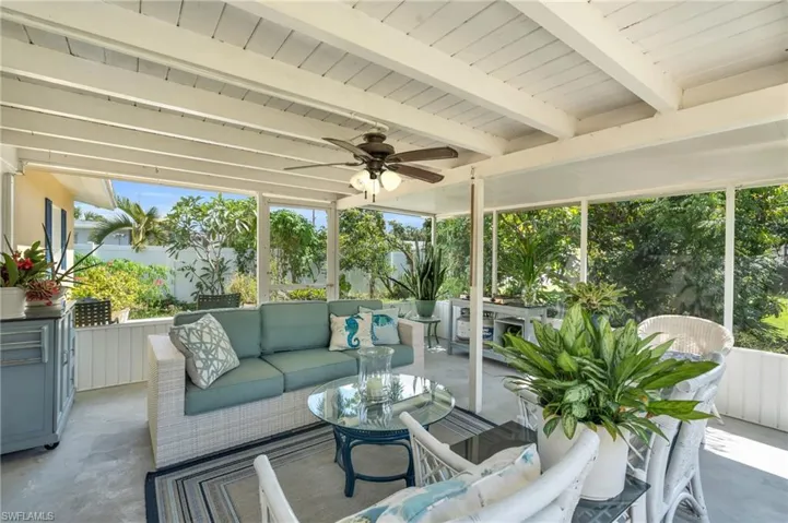 Sunroom featuring ceiling fan and beam ceiling
