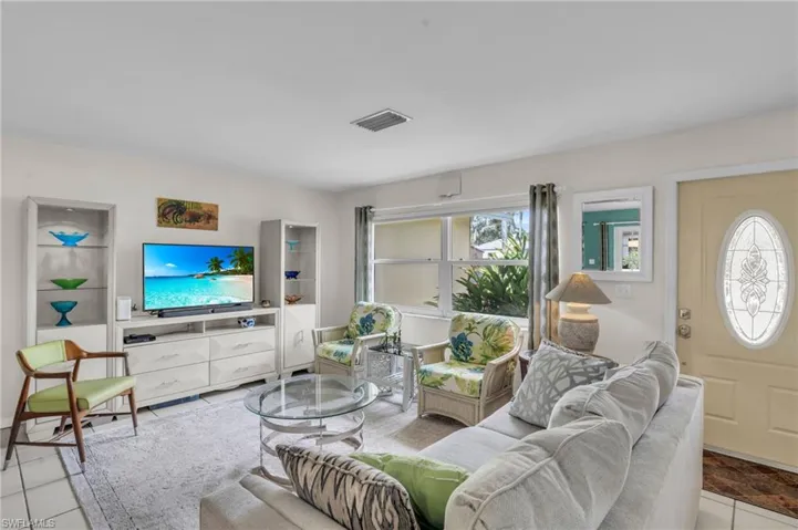 Living room with light tile patterned flooring and plenty of natural light