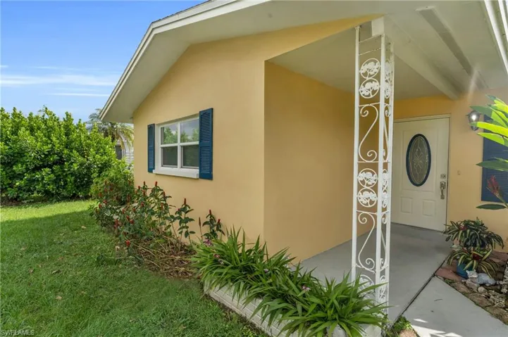 Doorway to property with a lawn