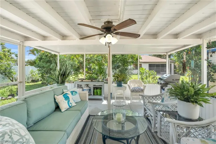 Sunroom / solarium featuring beam ceiling, ceiling fan, and wooden ceiling