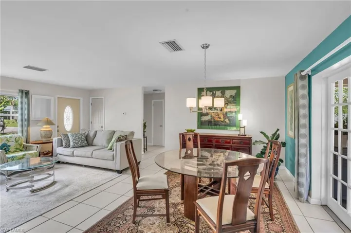 Dining room with a healthy amount of sunlight, light tile patterned floors, and a chandelier