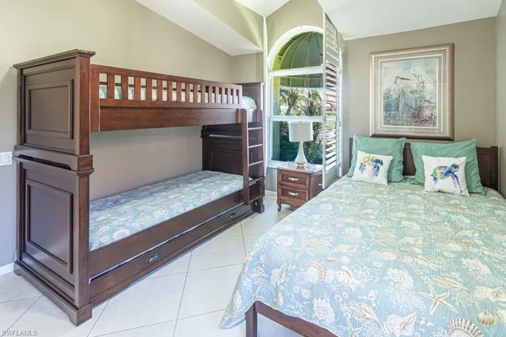 Tiled bedroom with baseboards and vaulted ceiling
