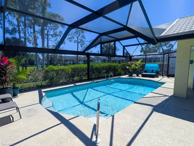 Outdoor pool featuring glass enclosure and a patio area