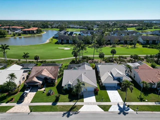 Drone / aerial view featuring golf course view, a water view, and a residential view