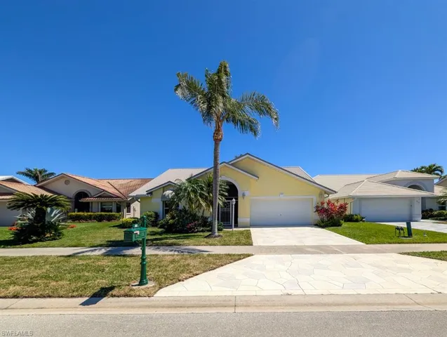 View of front of home featuring driveway, an attached garage, a front yard, and stucco siding