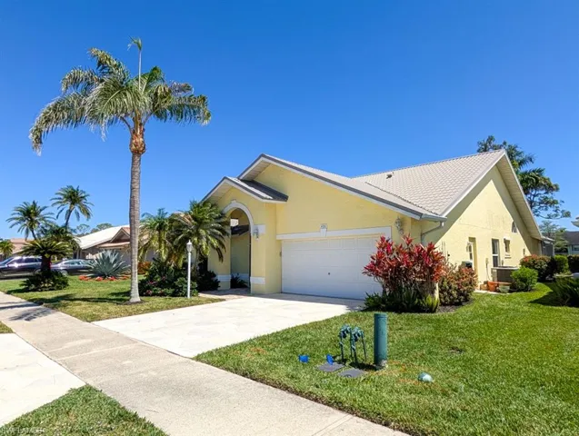 View of front of home with stucco siding, a garage, a front lawn, and concrete driveway