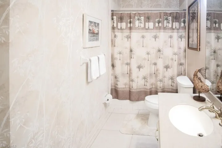 Full bath featuring toilet, vanity, and tile patterned flooring