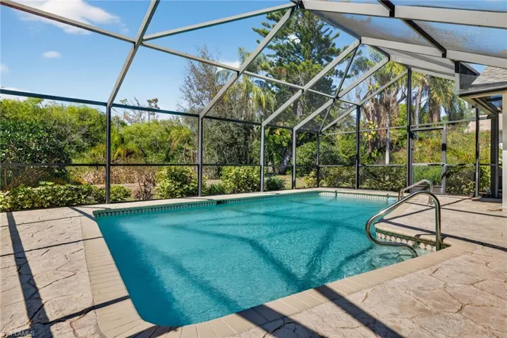 Swimming pool with a sunroom, a lanai, and a patio