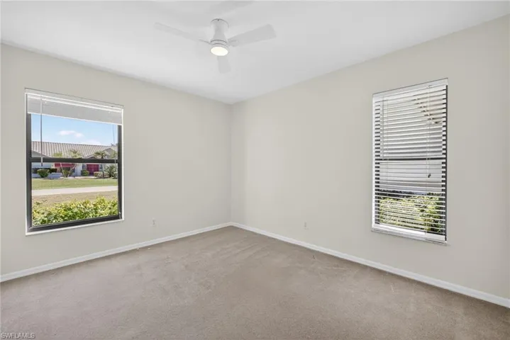 Empty room featuring ceiling fan and carpet