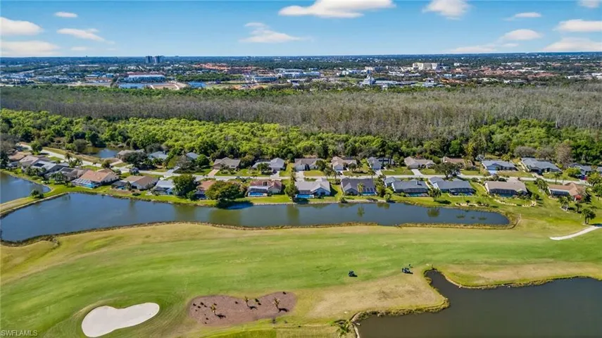 Aerial view of residential area with a local golf course and a large body of water