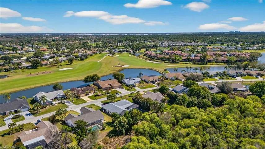 Aerial view of residential area with a nearby body of water and a local golf course