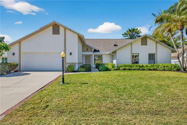 View of front of property featuring a garage, stucco siding, concrete driveway, a front lawn, and roof with shingles