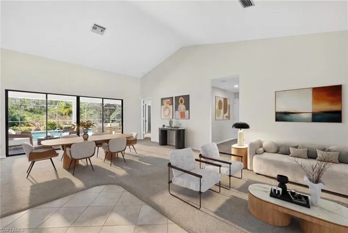 Living room featuring light carpet, light tile patterned floors, and a high ceiling