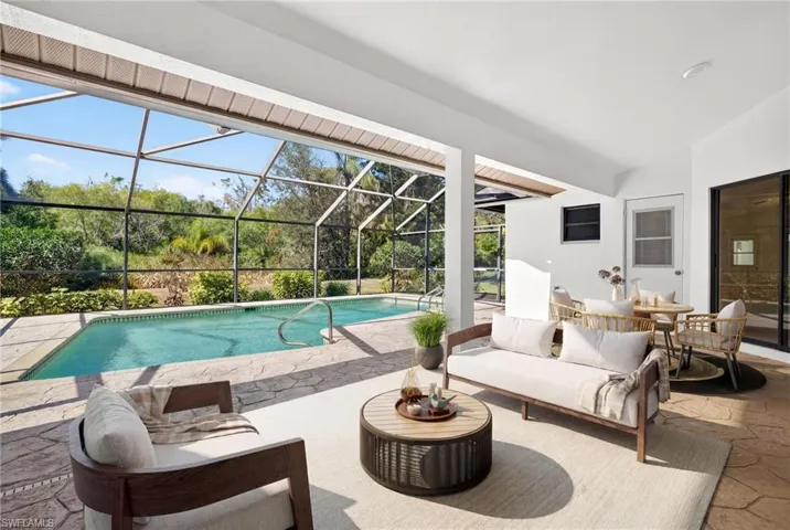 Outdoor pool with an outdoor living space, a patio, a sunroom, and glass enclosure