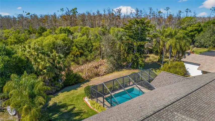 Swimming pool featuring a lanai, a sunroom, a lawn, and a patio