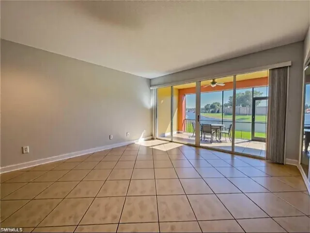 Empty room featuring baseboards, a ceiling fan, and light tile patterned floors