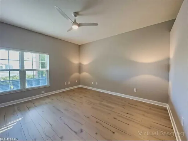 Empty room featuring baseboards, ceiling fan, and wood finished floors