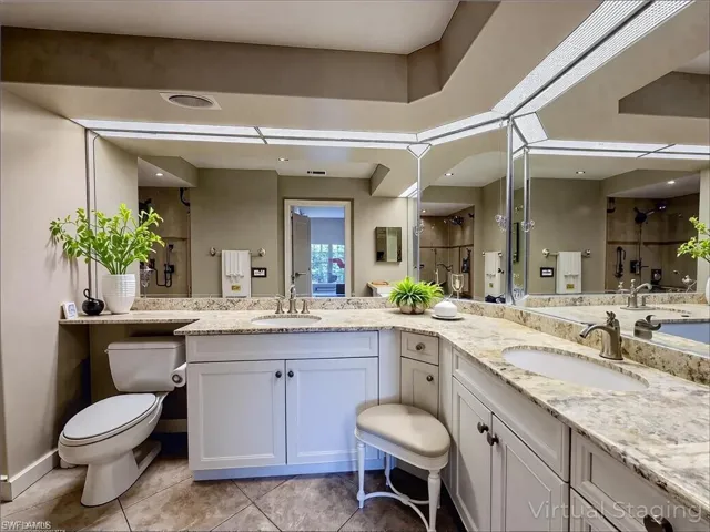 Bathroom with double vanity, a sink, toilet, and a shower stall