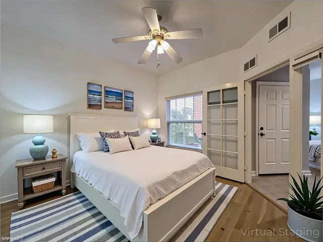 Bedroom featuring baseboards, ceiling fan, visible vents, and wood finished floors