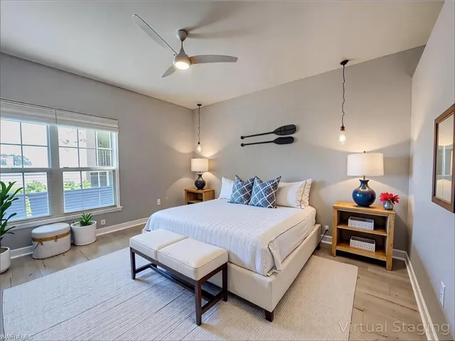 Bedroom with light wood finished floors, baseboards, and ceiling fan