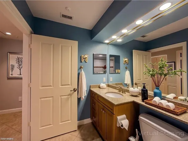 Bathroom with tile patterned floors, toilet, vanity, baseboards, and visible vents