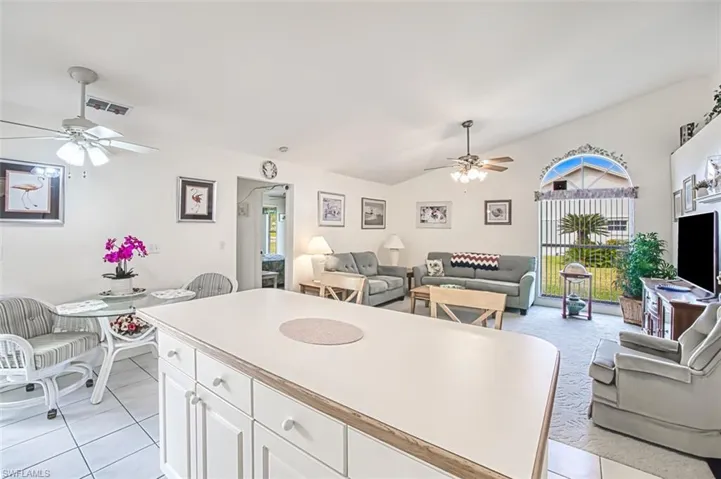 Kitchen with white cabinetry, light tile patterned floors, and ceiling fan