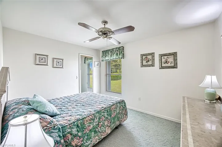 Carpeted bedroom featuring ceiling fan