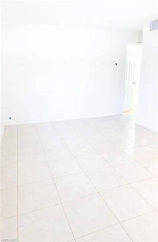 Spare room featuring light tile patterned floors and baseboards