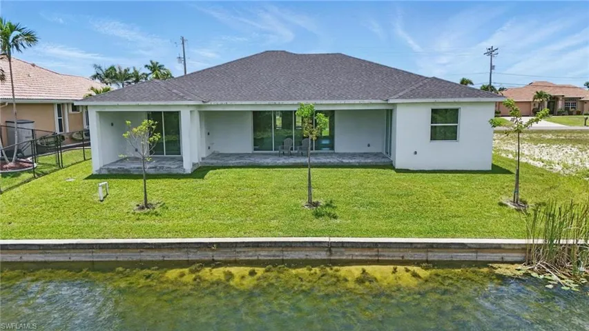 Back of property with stucco siding and a shingled roof