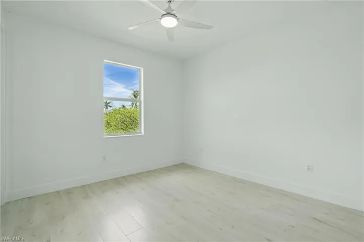 Empty room with light wood-type flooring, baseboards, and ceiling fan