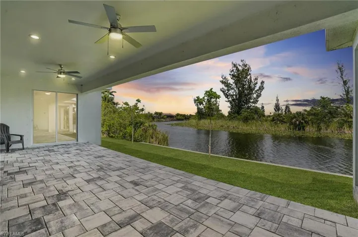 View of patio with a water view and a ceiling fan